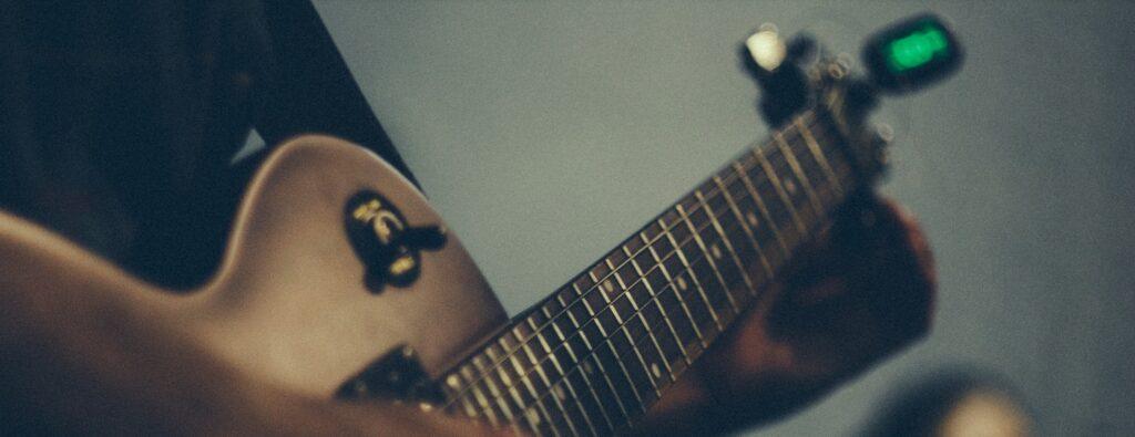 musician tuning electric guitar