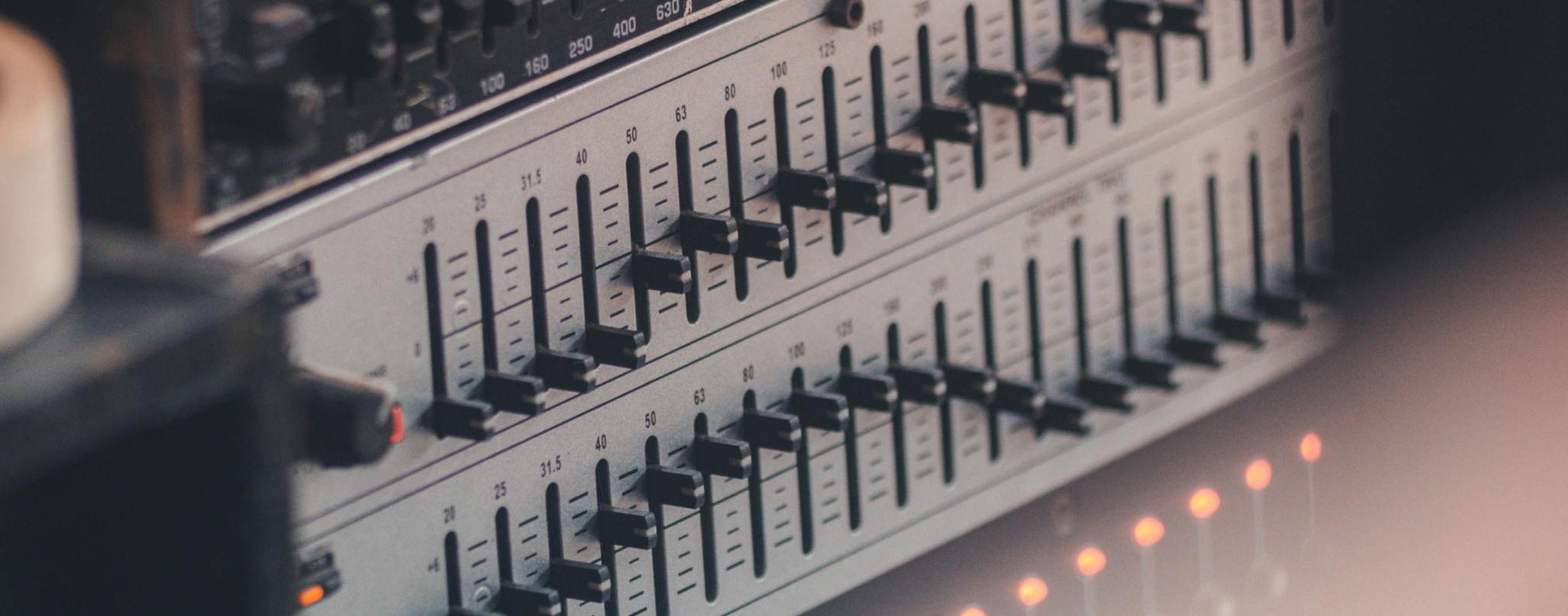 Close-up of a rackmount hardware graphic equalizer with frequency sliders