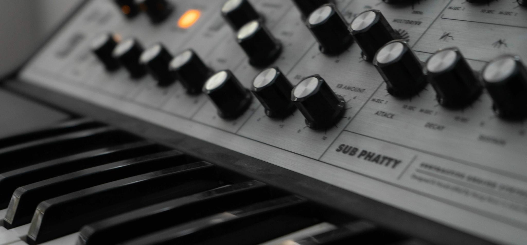 Close-up of a synthesizer with rotary knobs and keyboard keys