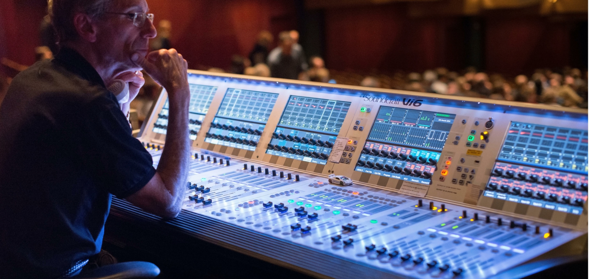 A sound engineer operating a Soundcraft Vi6 mixing console in a recording live performance