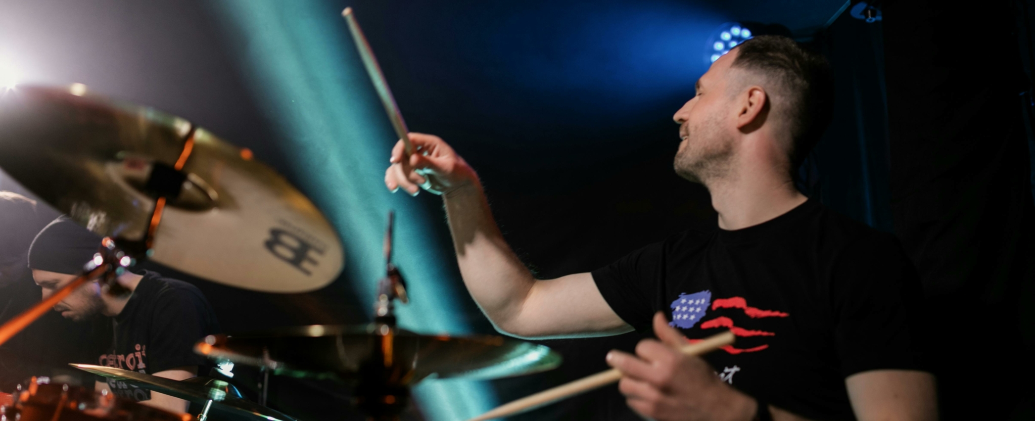 Drummer performing on stage with cymbals and drum set