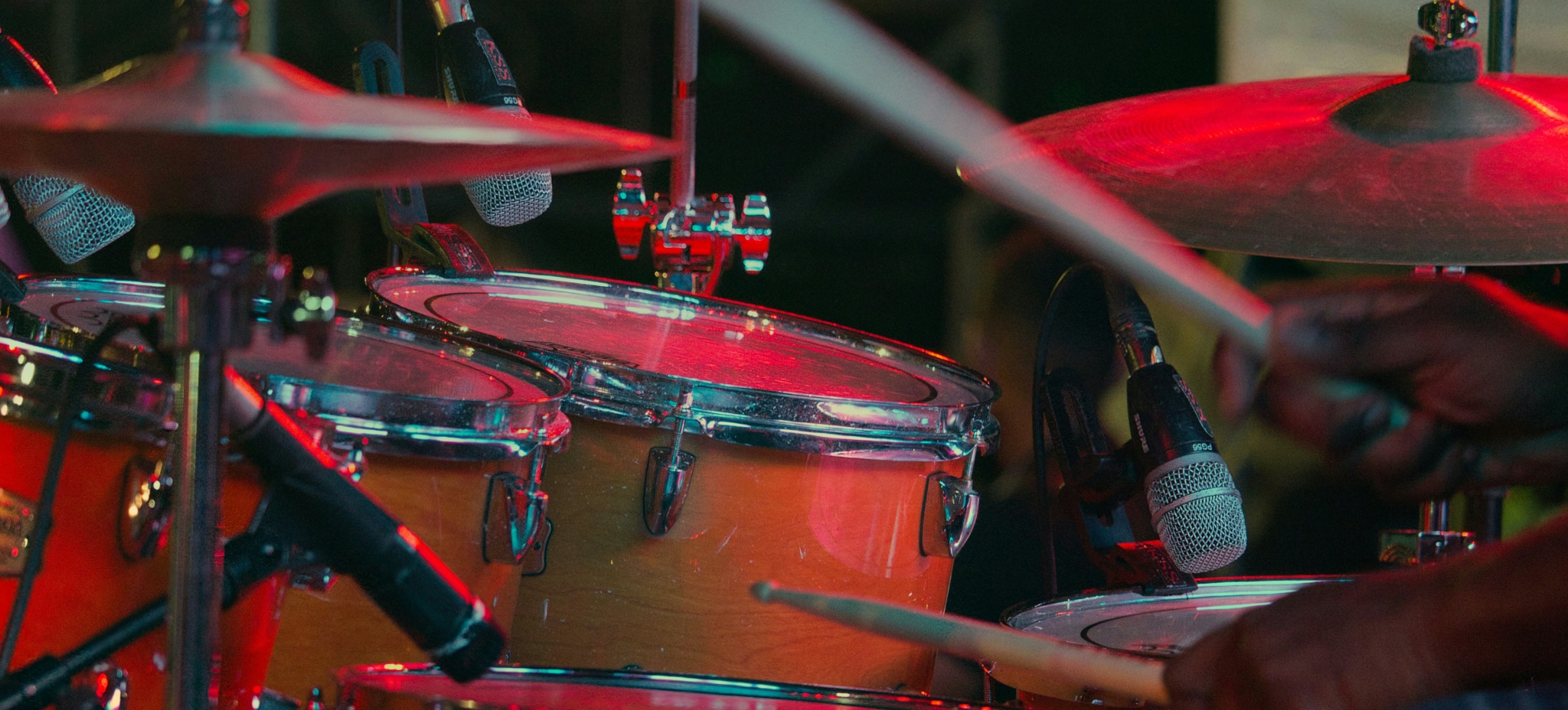 Drummer performing with drum kit and microphones