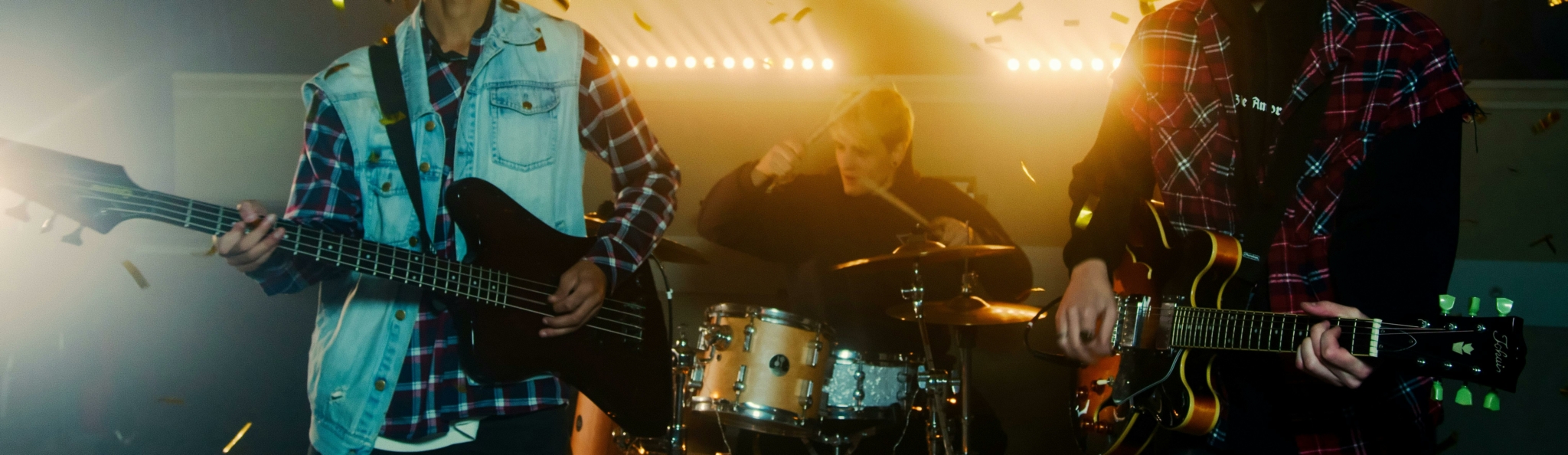 A lively band performance with musicians playing instruments amid golden confetti.
