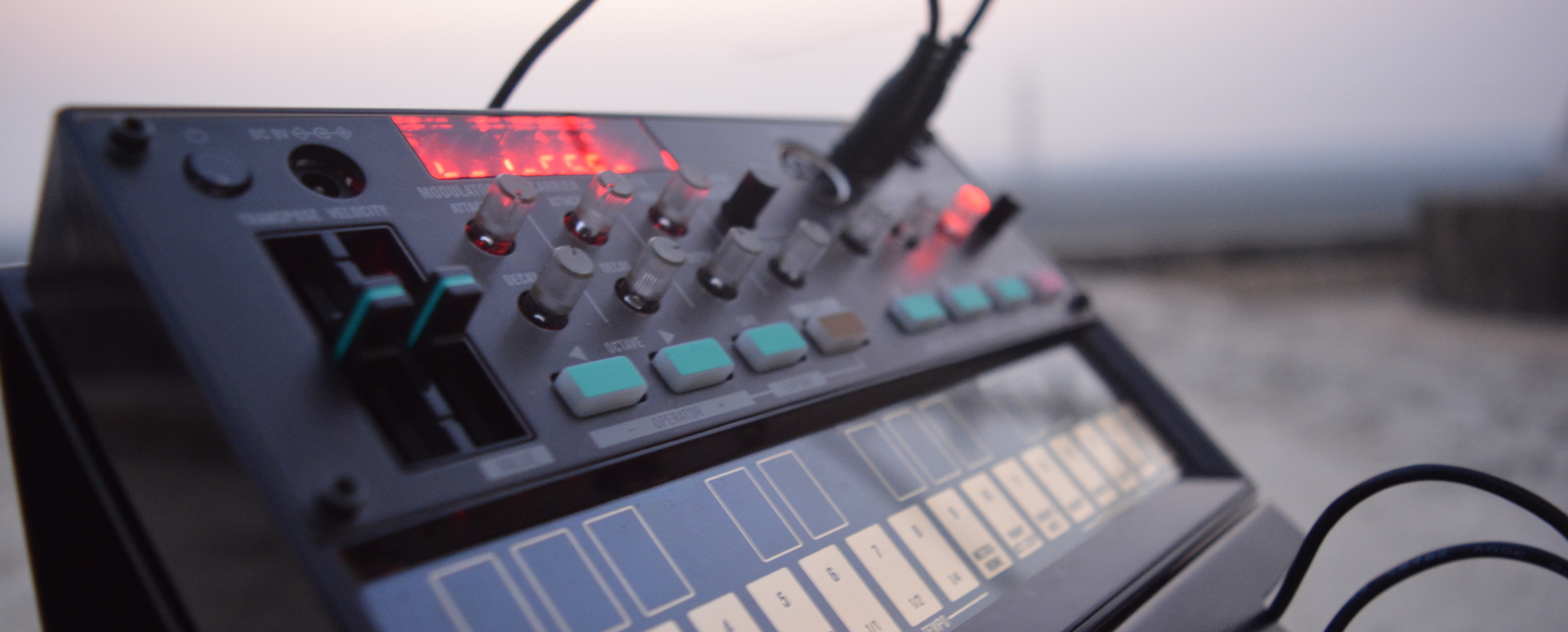 Close-up of a synthesizer with various knobs and buttons, showcasing vibrant lights.