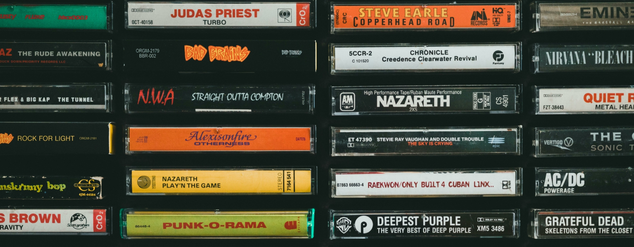 A collection of music cassette tapes featuring various artists and albums.