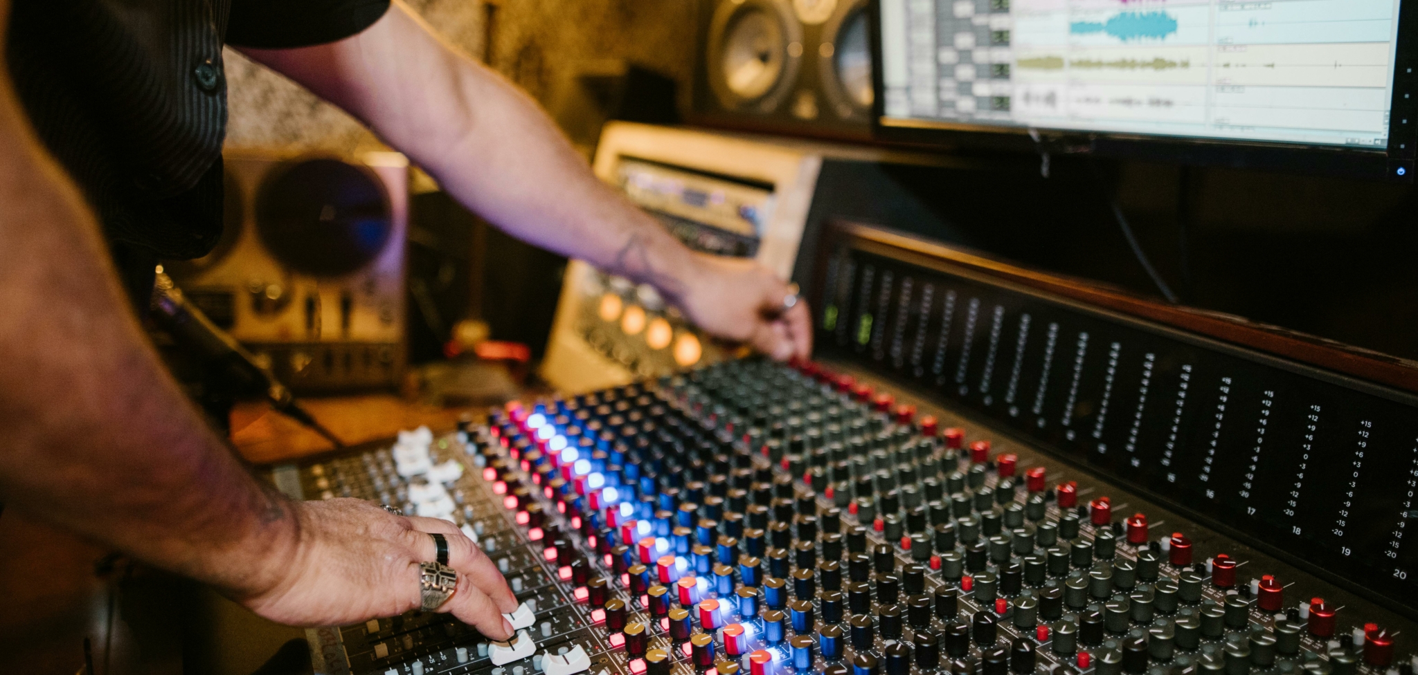 Audio mixing console with visible hand adjusting stereo balance