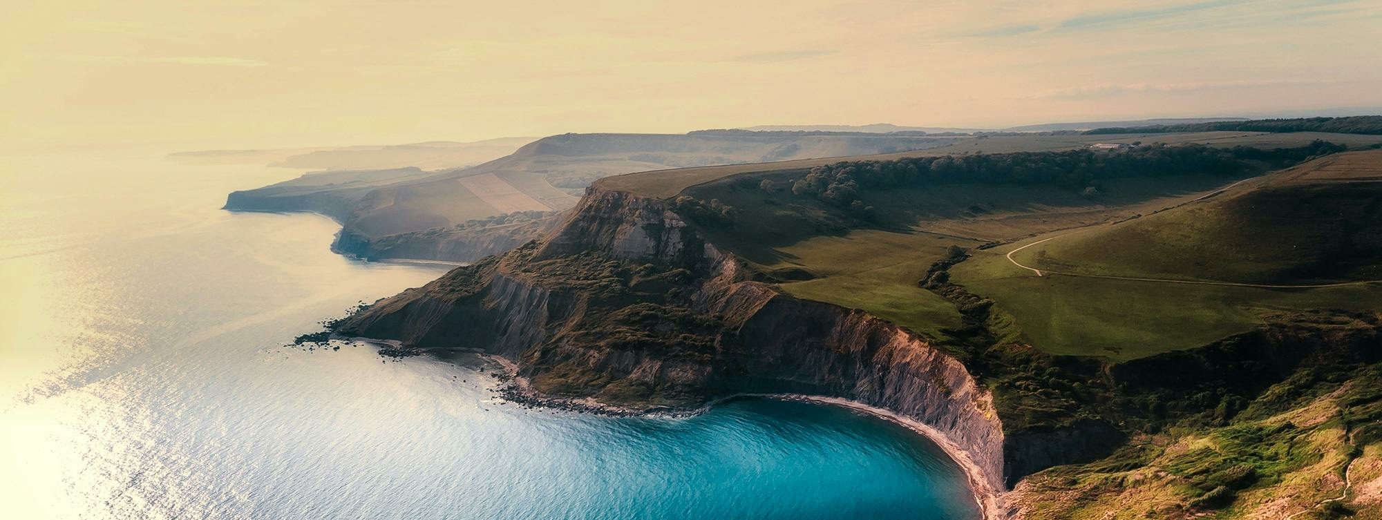 Aerial view of a coastal landscape featuring cliffs and a serene beach.