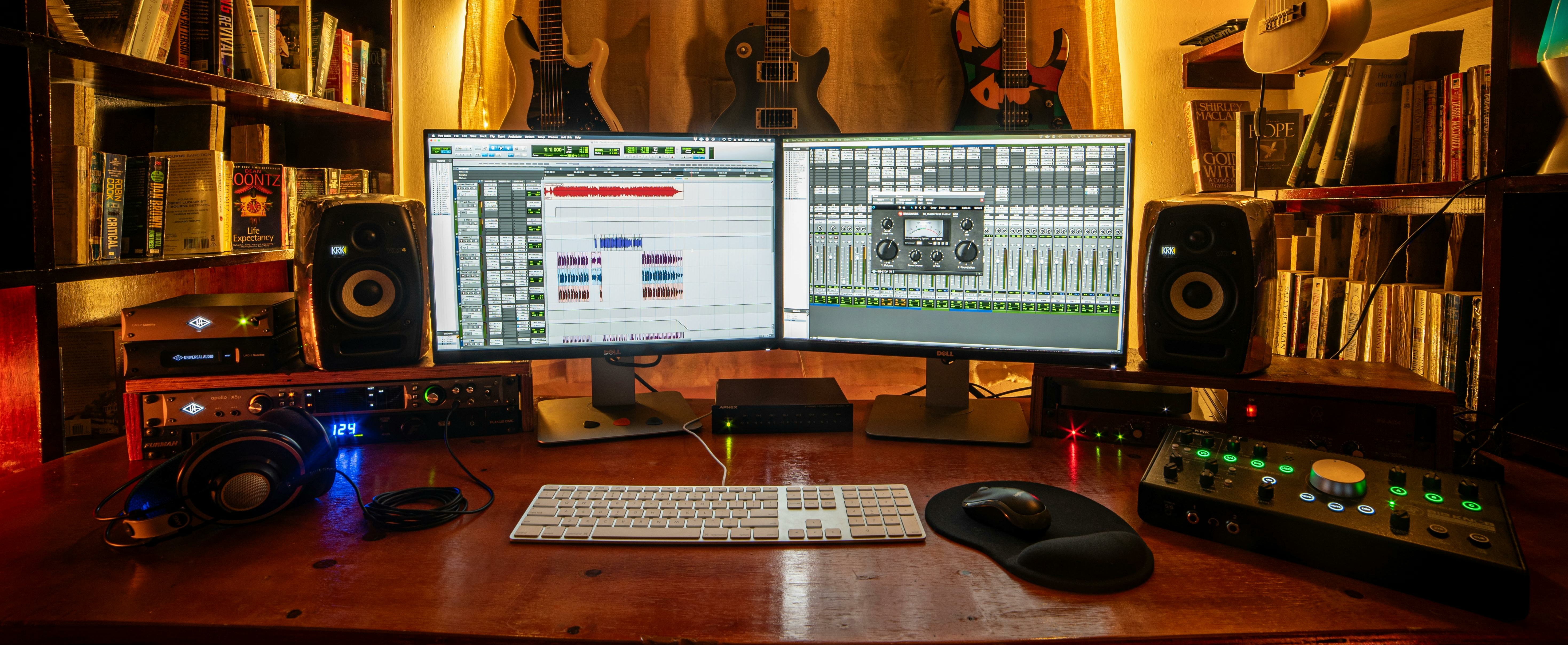 espacio de producción de audio con monitores, interfaz DAW y distintos instrumentos